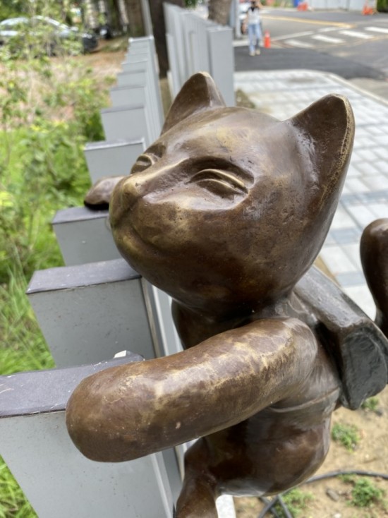 半夢(mèng)半醒的貓咪攀牆上學(xué)，摹寫著孩童們匆忙上學(xué)的日常，藝術(shù)家─曾永玲發(fā)揮天馬行空的想像投設(shè)其中。