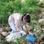 在卵礫石堆中藍色醒目的「皮球」，吸引了小朋友前去查看並拾起，一點一滴還給河川乾淨(jìng)的面貌。