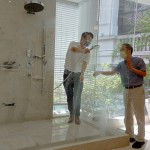 新業(yè)建設(shè)卓勝隆董事長（右）伸手測試三段式水流變化為肌膚帶來的觸感，親身體驗，精選出舒心的衛(wèi)浴設(shè)備。