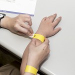 活動(dòng)開始之前，工作人員協(xié)助大、小朋友們戴上分組的幸運(yùn)手環(huán)。