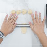 初體驗包月餅的新業(yè)同仁，一步步跟著講師的詳細教學，從秤重、桿捲、包覆、裝飾，到送入烤箱。 