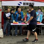 現(xiàn)場新業(yè)建設(shè)穆椿松名譽(yù)董事長（左二）與卓勝隆董事長（左一）引領(lǐng)大家，加油吶喊給予跑者支持。