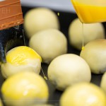 刷上蛋黃液，點上芝麻裝飾，圓潤蓬鬆的蛋黃酥即將穿上金黃酥脆的外衣。