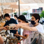 從攤販?zhǔn)种薪舆^最適合午後享用的輕食，攤販同時將心意以雙手一同遞上，彼此的這份互動是盛夏美好的一景。