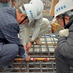 由新業(yè)建設名譽董事長穆椿松先生（圖左一）、卓勝隆董事長（圖右一）一同親手將主角「噴金漆鋼筋」綁紮、安置於屋頂中樑位置，代表著建築的穩(wěn)定與安詳。