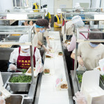 新業(yè)同仁與甘霖志工們分工合作，以生產(chǎn)線的方式有序地進(jìn)行，將熱騰騰的餐食迅速裝盒，確保長(zhǎng)輩能準(zhǔn)時(shí)享用午餐。